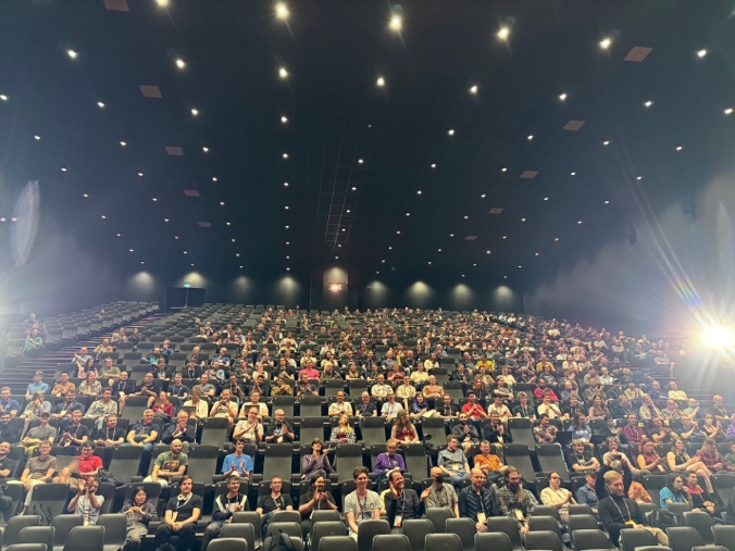 A large group of people in a auditorium AI-generated content may be incorrect.